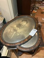 Both oval frames stacked showing wood finish and convex glass