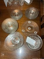 Stacks of Cornflower etched glass small plates and one bowl on wooden table