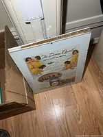 Framed Dionne Quintuplets advertisement leaning against wall