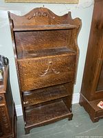 Front view showing drop-front desk and shelves