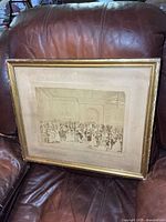 Full view of framed photograph resting on leather couch