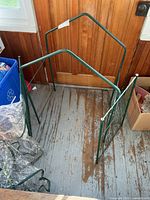 green metal frame parts arranged on floor