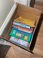 Box containing stack of books, spines visible