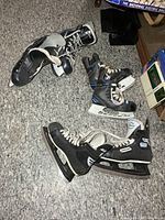 Three pairs of hockey skates on floor