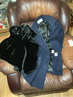 Wool coat and faux fur vest displayed on armchair