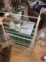 Full view of white metal drying rack alongside other laundry items