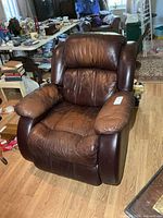 Front view of brown leather rocker recliner showing overall design and wear