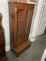 Front view of solid wood cabinet with glass doors and base drawers