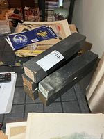 Stack of five black boxed piano rolls on tabletop