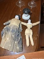 Two porcelain head dolls and extra porcelain head on table