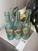 Four aqua Cantrell & Cochrane ginger ale bottles grouped together