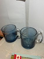 Pair of blue glass mugs on tabletop