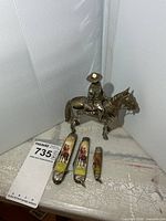 figurine with three pocket knives and lot tag