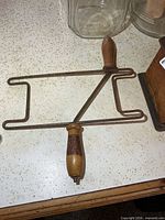 Full view of rope winder showing metal frame and both wood handles