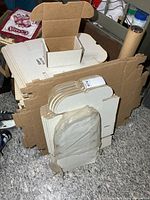 stack of assorted flat unassembled cardboard box blanks brown and white