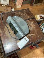 Top view showing overall clock radio, AC cord, speaker grille, buttons