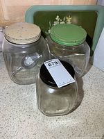 All three glass canisters with different colored lids and visible scoop