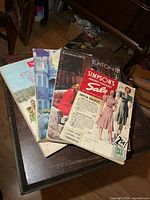Four stacked vintage catalogs showing Simpson's, Eaton's, Sears and an additional issue