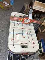 Full view of tabletop hockey game with overhead scoreboard