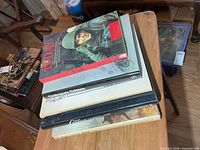 Stacked view of five war books on table