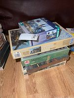 Stack of five war-themed puzzle boxes showing brands, piece counts, and that one is sealed