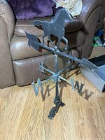 Full view of cast aluminum rooftop weather vane with horse, arrow and directional letters