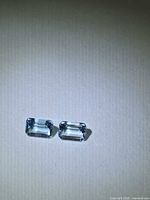Front view of both emerald-cut aquamarines