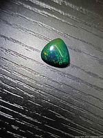Top view of the trillion black opal showing play-of-colour