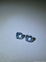 Both aquamarine gemstones front view on textured surface