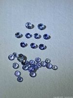 Group of loose round faceted Tanzanite stones on neutral background