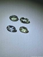 Four views of the faceted oval lemon-lime gemstone
