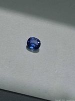 Top view of the loose oval blue sapphire on neutral background