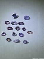 All 15 loose faceted pink tanzanite gemstones displayed