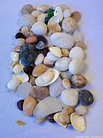 Top view of entire mix of stones, sea glass and shells on cloth background