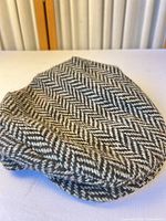 Side view of flat cap showing herringbone pattern and shape