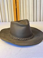 Side perspective of Henschel brown leather outback hat showing braided band and brim