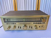 Front and top view of Soundesign TX 5160 receiver showing gold faceplate, knobs, wood veneer cabinet