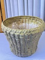 Front view of ceramic planter showing bamboo relief texture and yellow speckled glaze