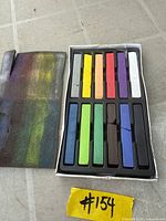 Open box showing twelve square pastel sticks and foam insert