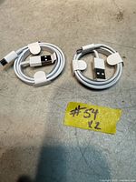 Two coiled white Lightning to USB-A cables with paper wraps