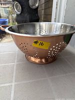 Side view of copper exterior and stainless interior with handle and foot visible