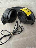 Front angle of folded Corseca wired headphones showing earcup branding and attached cable