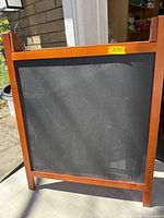 Front view showing black chalkboard surface within wood frame