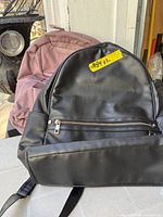 Front view of both backpacks showing colors, material and front pockets