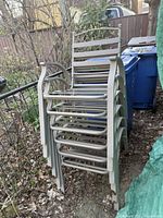 Stack of six matching metal patio armchairs
