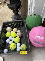 overview of basket with golf, tennis, baseballs plus two larger balls