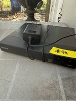 Sony DVD player with attached AC adapter on tabletop