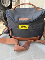 Front view of Tommy Bahama cooler bag showing overall design, front pocket, shoulder strap and handle