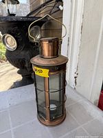 Full view of vintage copper outdoor lantern with handle and candle inside