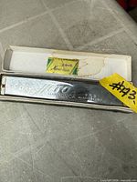 Hero harmonica inside open cardboard case with label